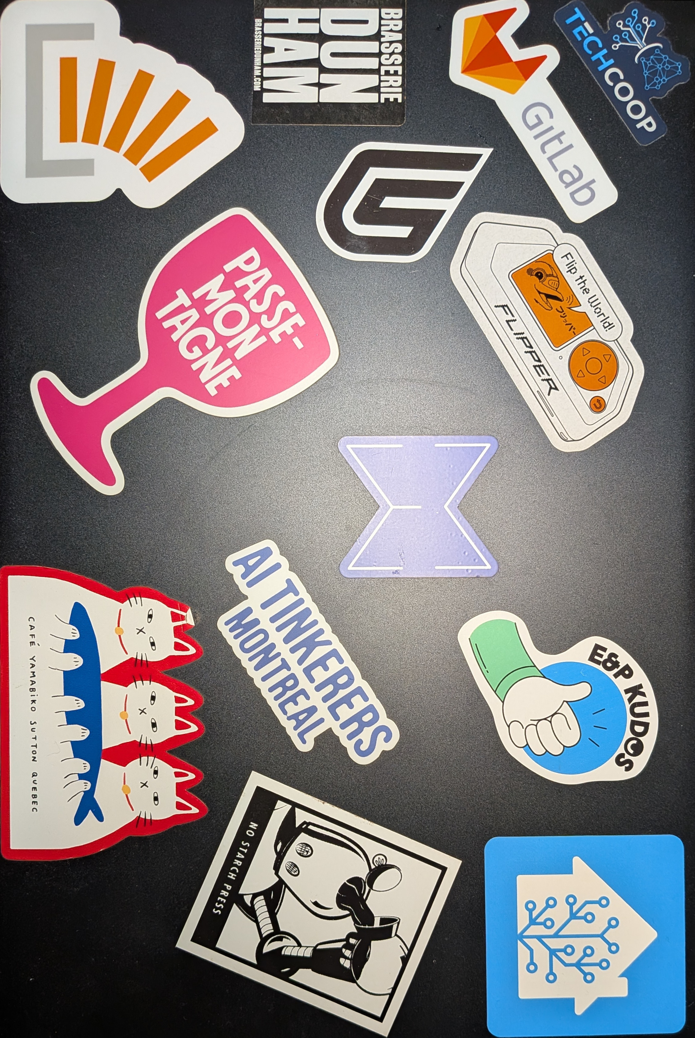 Image of the closed lid of a Pinebook Pro laptop with stickers on it